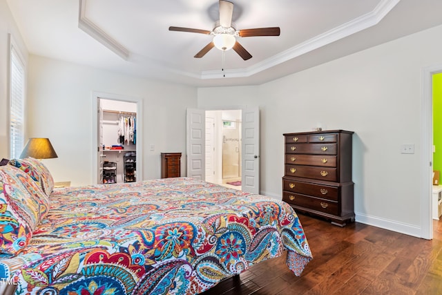 100 Lexington Ave, Zebulon, NC 27597 - bedroom featuring ornamental molding, dark wood finished floors, a tray ceiling, a spacious closet, and connected bathroom