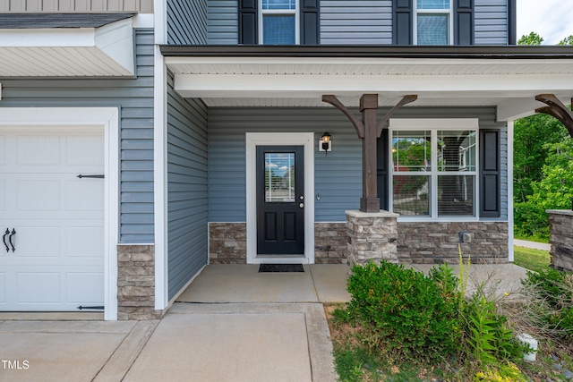 173 Forsyth Pkwy, Clayton, NC 27520 - property entrance featuring stone siding, a porch, and an attached garage
