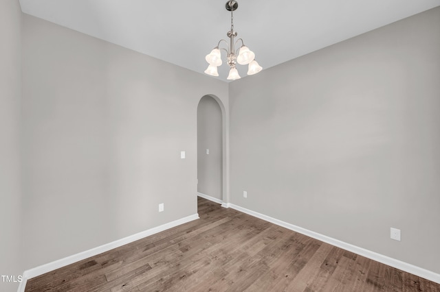 173 Forsyth Pkwy, Clayton, NC 27520 - spare room with arched walkways, wood finished floors, baseboards, and a chandelier