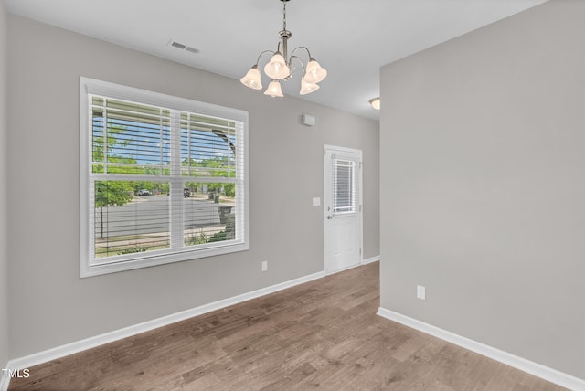 173 Forsyth Pkwy, Clayton, NC 27520 - spare room with a chandelier, baseboards, and wood finished floors