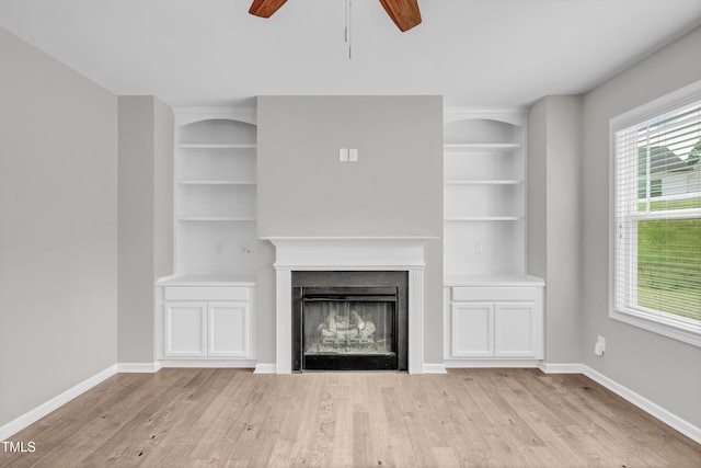 173 Forsyth Pkwy, Clayton, NC 27520 - unfurnished living room featuring a ceiling fan, light wood-type flooring, built in shelves, and baseboards