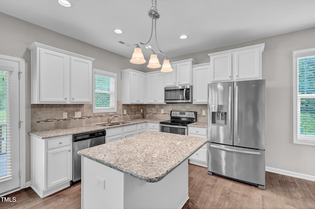 173 Forsyth Pkwy, Clayton, NC 27520 - kitchen featuring appliances with stainless steel finishes, a sink, white cabinetry, wood finished floors, and recessed lighting
