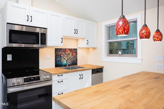126 Barclay Rd, Chapel Hill, NC 27516 - kitchen with butcher block countertops, appliances with stainless steel finishes, vaulted ceiling, white cabinets, and hanging light fixtures