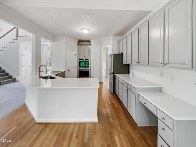 105 Crosswaite Way, Cary, NC 27518 - kitchen with a sink, stainless steel appliances, light wood finished floors, light countertops, and gray cabinetry