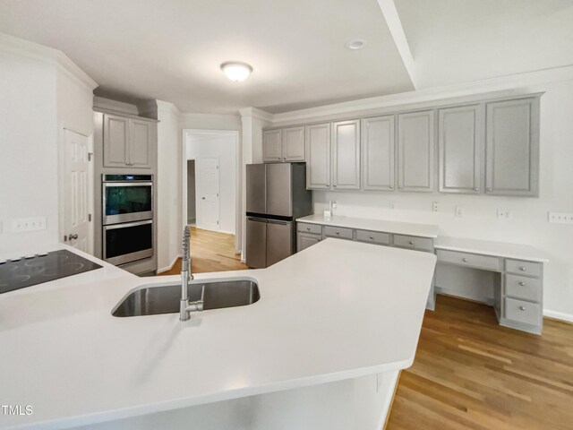105 Crosswaite Way, Cary, NC 27518 - kitchen featuring stainless steel appliances, a sink, light wood-style flooring, gray cabinetry, and light countertops