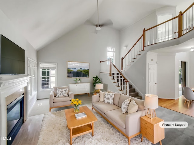 105 Crosswaite Way, Cary, NC 27518 - living area with high vaulted ceiling, healthy amount of natural light, stairs, a ceiling fan, and a high end fireplace