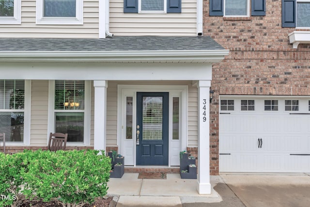 3449 S Beaver Ln, Raleigh, NC 27604 - entrance to property featuring a porch, a garage, roof with shingles, and brick siding