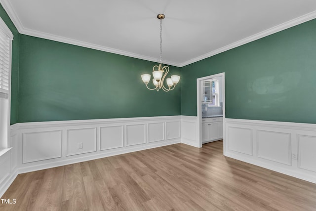 3449 S Beaver Ln, Raleigh, NC 27604 - spare room featuring a chandelier, crown molding, a wainscoted wall, light wood-style floors, and a decorative wall