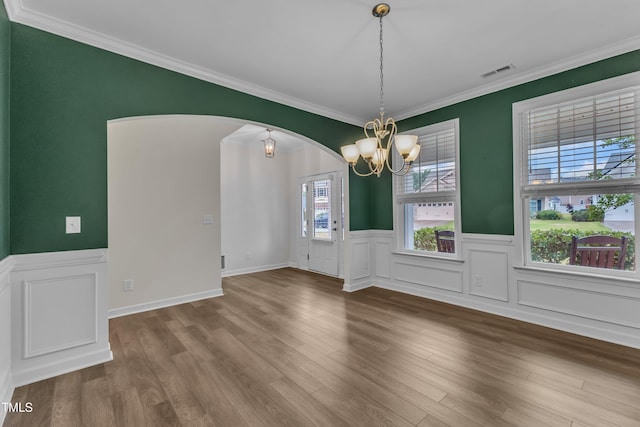 3449 S Beaver Ln, Raleigh, NC 27604 - unfurnished dining area with a chandelier, arched walkways, wainscoting, wood finished floors, and ornamental molding