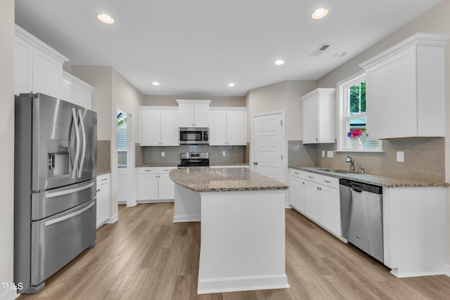 3449 S Beaver Ln, Raleigh, NC 27604 - kitchen with stainless steel appliances, a sink, a kitchen island, white cabinets, and recessed lighting