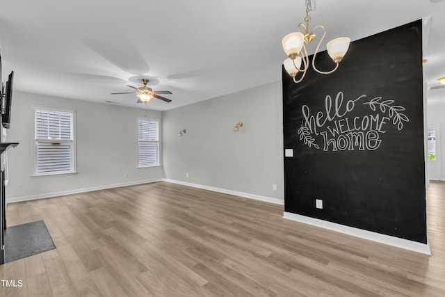 3449 S Beaver Ln, Raleigh, NC 27604 - unfurnished living room featuring light wood-type flooring, a ceiling fan, baseboards, and a chandelier