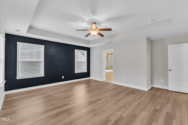 3449 S Beaver Ln, Raleigh, NC 27604 - unfurnished room with a tray ceiling, a ceiling fan, light wood-type flooring, and baseboards