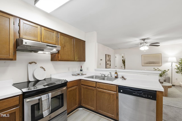 407 Gooseneck Dr Unit B1, Cary, NC 27513 - kitchen with stainless steel appliances, under cabinet range hood, a peninsula, brown cabinetry, and light countertops