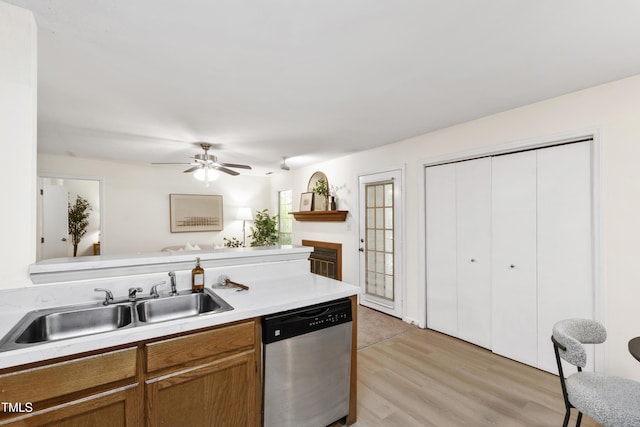 407 Gooseneck Dr Unit B1, Cary, NC 27513 - kitchen with stainless steel dishwasher, light wood finished floors, brown cabinets, light countertops, and ceiling fan