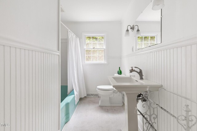 816 Miller Rd, Hillsborough, NC 27278 - bathroom featuring a wainscoted wall, toilet, plenty of natural light, shower / bath combo with shower curtain, and a sink