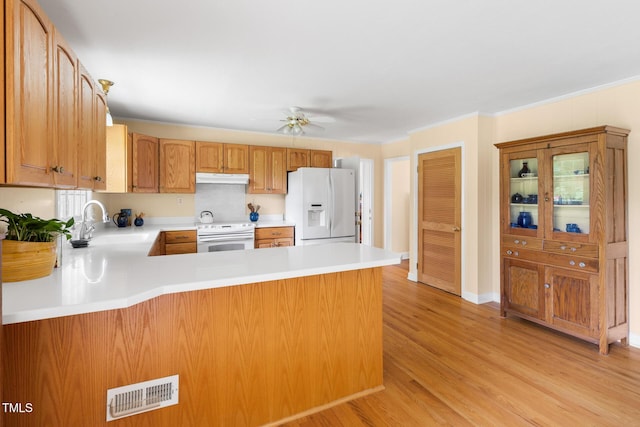 816 Miller Rd, Hillsborough, NC 27278 - kitchen with white appliances, a sink, under cabinet range hood, a peninsula, and light countertops