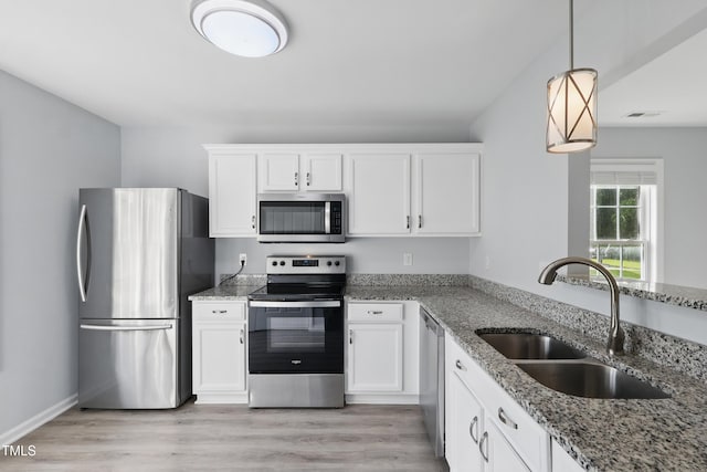 5408 Gunnette Dr, Raleigh, NC 27610 - kitchen featuring stainless steel appliances, a sink, white cabinets, light stone counters, and light wood-type flooring