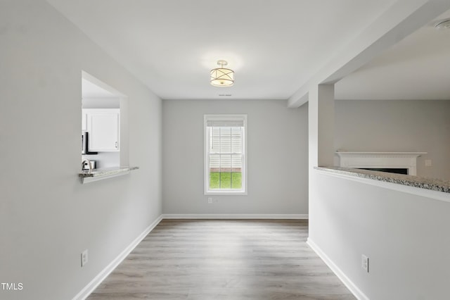 5408 Gunnette Dr, Raleigh, NC 27610 - unfurnished dining area featuring wood finished floors, a fireplace, and baseboards