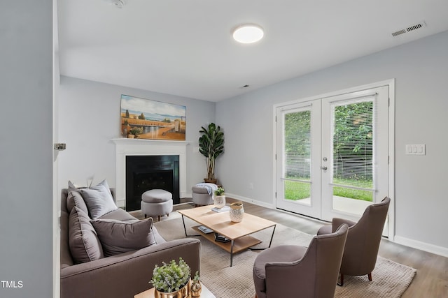 5408 Gunnette Dr, Raleigh, NC 27610 - living area with french doors, light wood-style floors, baseboards, and a fireplace