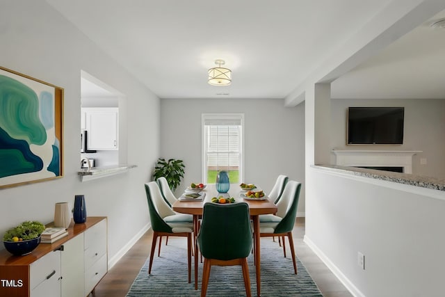 5408 Gunnette Dr, Raleigh, NC 27610 - dining area featuring dark wood-type flooring, baseboards, and a fireplace