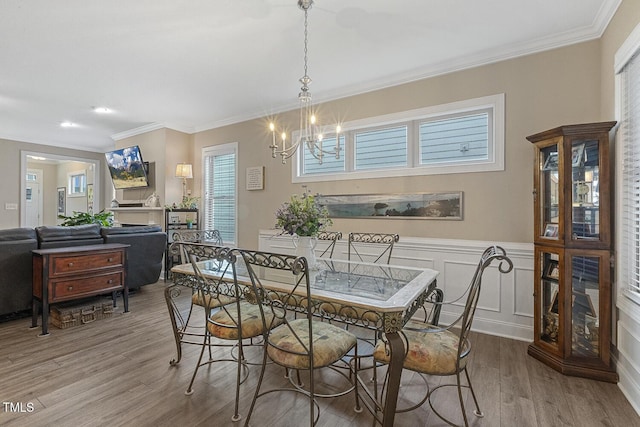 1374 Patriot Points Way, Fuquay Varina, NC 27526 - dining space featuring a chandelier, wood finished floors, crown molding, plenty of natural light, and wainscoting