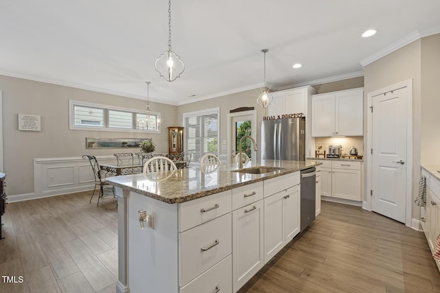 1374 Patriot Points Way, Fuquay Varina, NC 27526 - kitchen featuring appliances with stainless steel finishes, a sink, white cabinets, light stone countertops, and crown molding