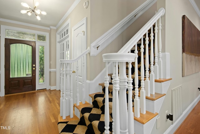 4021 Chaumont Dr, Apex, NC 27539 - foyer with wood finished floors, a chandelier, stairs, crown molding, and baseboards
