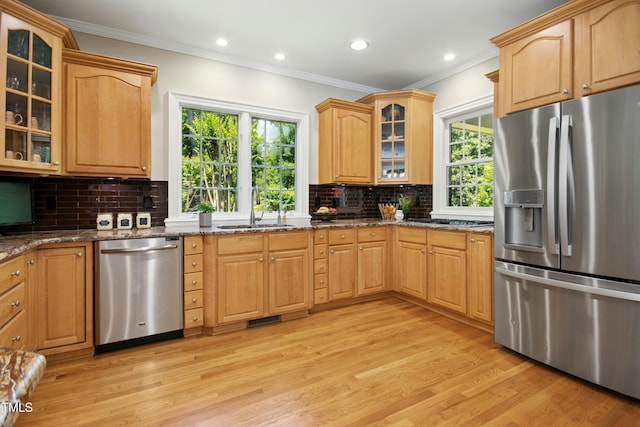 4021 Chaumont Dr, Apex, NC 27539 - kitchen featuring stainless steel appliances, a sink, crown molding, light wood-style floors, and dark stone countertops