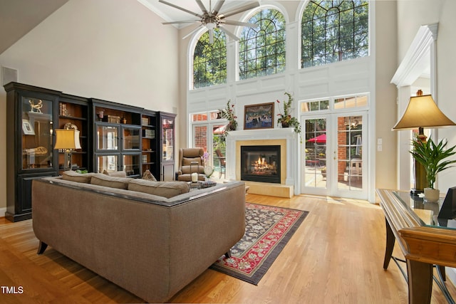4021 Chaumont Dr, Apex, NC 27539 - living room with a ceiling fan, a high ceiling, light wood-style floors, a glass covered fireplace, and ornamental molding