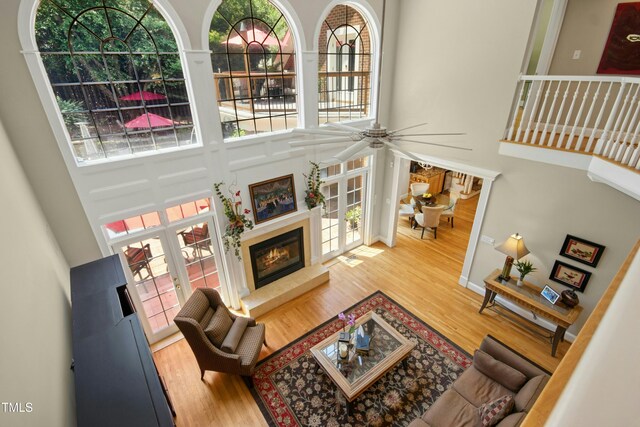 4021 Chaumont Dr, Apex, NC 27539 - living room with a towering ceiling, wood finished floors, a glass covered fireplace, and ceiling fan