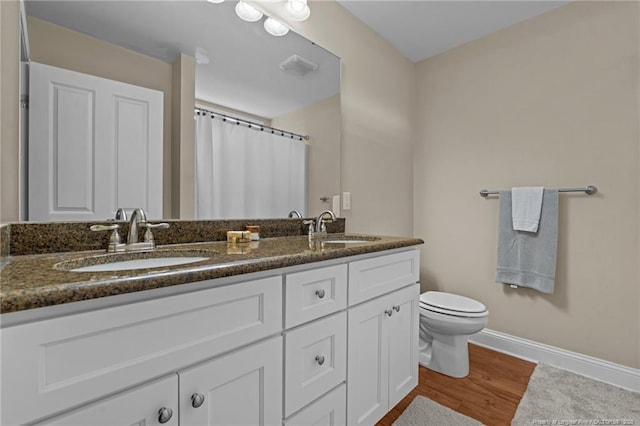 345 Pickett Cir, Vass, NC 28394 - bathroom with double vanity, toilet, wood finished floors, baseboards, and a shower with shower curtain