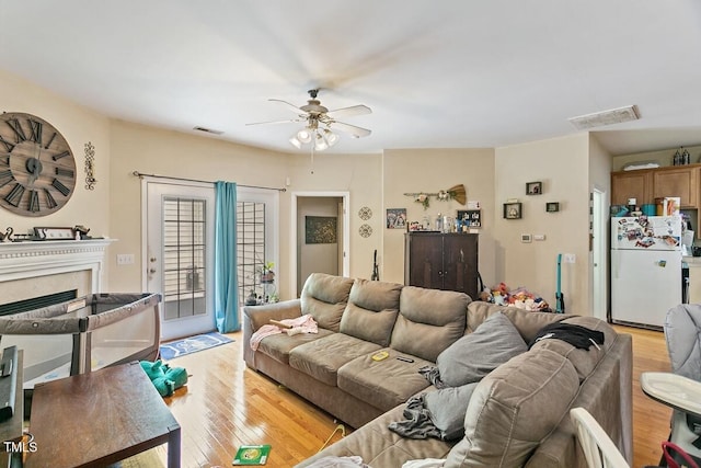 320 Madres Ln, Morrisville, NC 27560 - living room featuring light wood-style floors, ceiling fan, and a fireplace