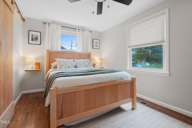 729 Mial St, Raleigh, NC 27608 - bedroom featuring wood finished floors, a barn door, baseboards, crown molding, and a ceiling fan