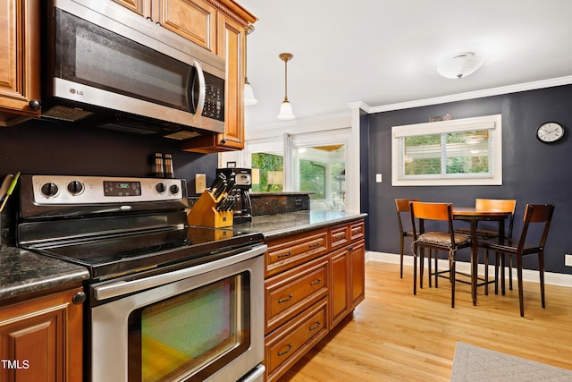 2805 Friendship Rd, Durham, NC 27705 - kitchen featuring appliances with stainless steel finishes, brown cabinets, light wood finished floors, dark countertops, and crown molding