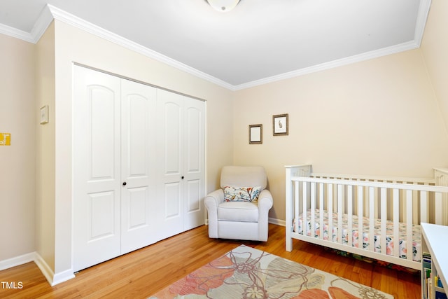 2805 Friendship Rd, Durham, NC 27705 - bedroom featuring wood finished floors, a closet, crown molding, baseboards, and a crib