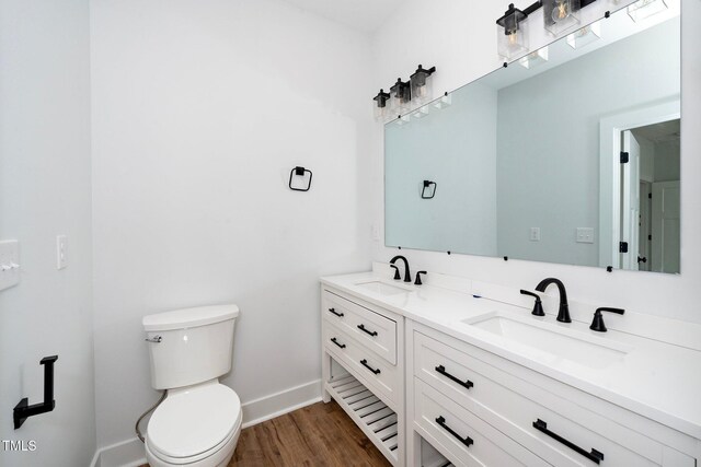 2517 Newbold St, Raleigh, NC 27603 - bathroom with double vanity, wood finished floors, toilet, and baseboards