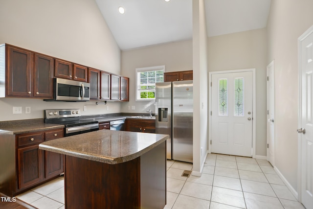 106 Gumdrop Path, Apex, NC 27502 - kitchen featuring appliances with stainless steel finishes, dark countertops, a sink, high vaulted ceiling, and light tile patterned floors