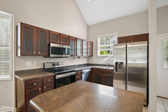 106 Gumdrop Path, Apex, NC 27502 - kitchen featuring stainless steel appliances, dark countertops, a sink, high vaulted ceiling, and light tile patterned floors