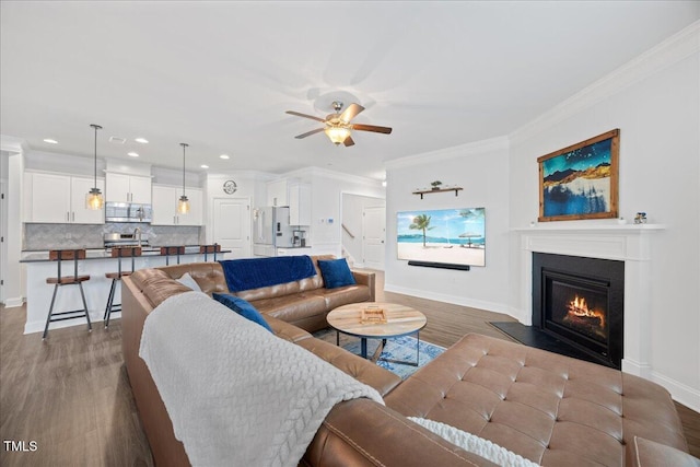 247 Axis Deer Ln, Garner, NC 27529 - living room with wood finished floors, baseboards, crown molding, a ceiling fan, and a glass covered fireplace