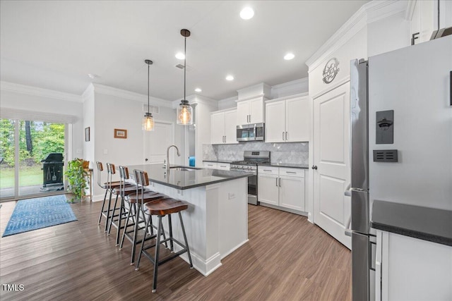 247 Axis Deer Ln, Garner, NC 27529 - kitchen with stainless steel appliances, dark wood finished floors, dark countertops, ornamental molding, and tasteful backsplash
