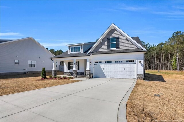 91 Laramie Ln, Selma, NC 27576 - craftsman-style house with covered porch, driveway, a front yard, and stone siding