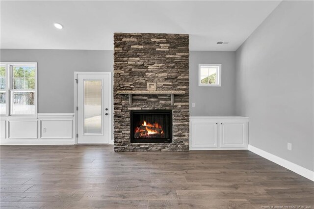 91 Laramie Ln, Selma, NC 27576 - unfurnished living room featuring healthy amount of natural light, a fireplace, and wood finished floors