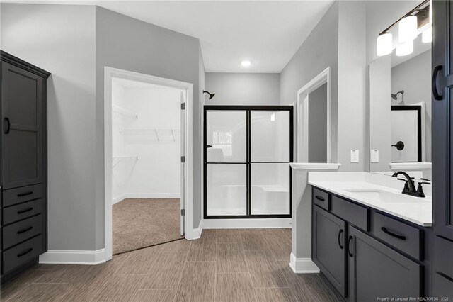 91 Laramie Ln, Selma, NC 27576 - bathroom with a shower stall, vanity, a walk in closet, and baseboards