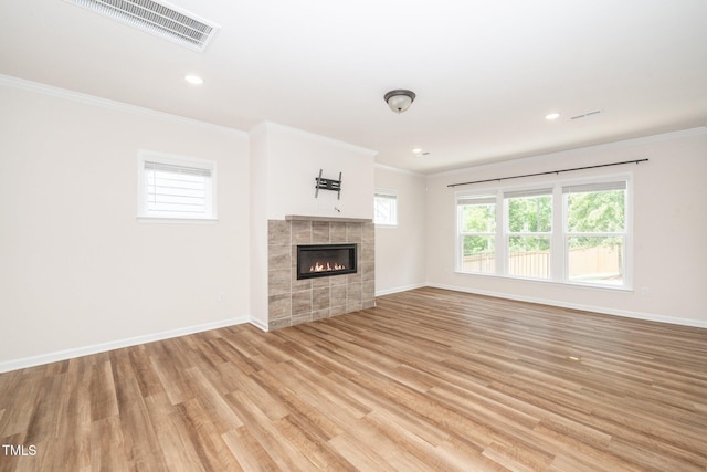 2619 Bordwell Grant Dr, New Hill, NC 27562 - unfurnished living room featuring light wood-style floors, crown molding, baseboards, a tile fireplace, and recessed lighting