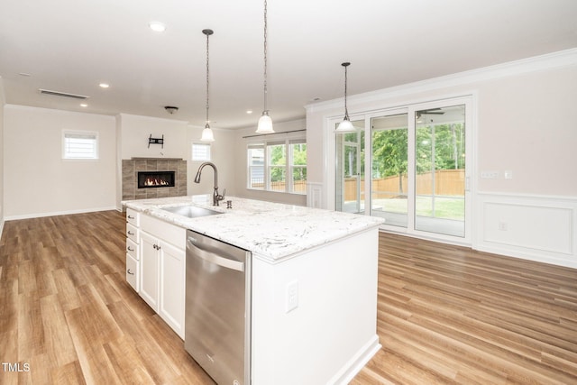 2619 Bordwell Grant Dr, New Hill, NC 27562 - kitchen featuring dishwasher, a sink, open floor plan, a fireplace, and white cabinetry