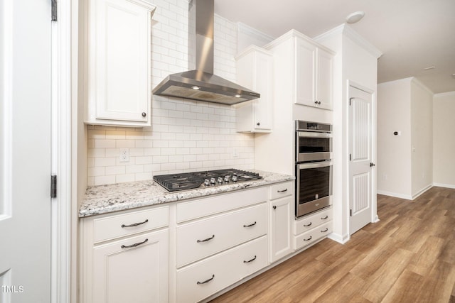 2619 Bordwell Grant Dr, New Hill, NC 27562 - kitchen featuring wall chimney range hood, stainless steel appliances, light wood-style floors, decorative backsplash, and white cabinets