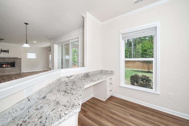 2619 Bordwell Grant Dr, New Hill, NC 27562 - kitchen with ornamental molding, wood finished floors, baseboards, light stone countertops, and decorative light fixtures