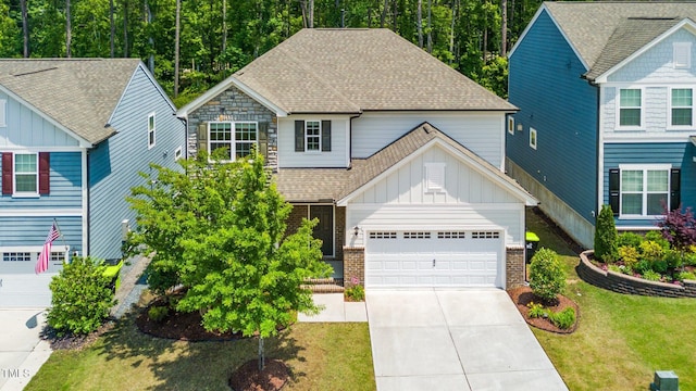 2619 Bordwell Grant Dr, New Hill, NC 27562 - view of front of home featuring board and batten siding, roof with shingles, concrete driveway, an attached garage, and a front yard
