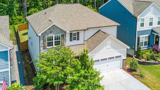 2619 Bordwell Grant Dr, New Hill, NC 27562 - traditional-style house with board and batten siding, an attached garage, roof with shingles, driveway, and stone siding
