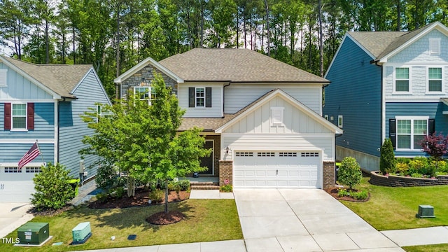2619 Bordwell Grant Dr, New Hill, NC 27562 - view of front of home with board and batten siding, a shingled roof, driveway, a front yard, and a garage